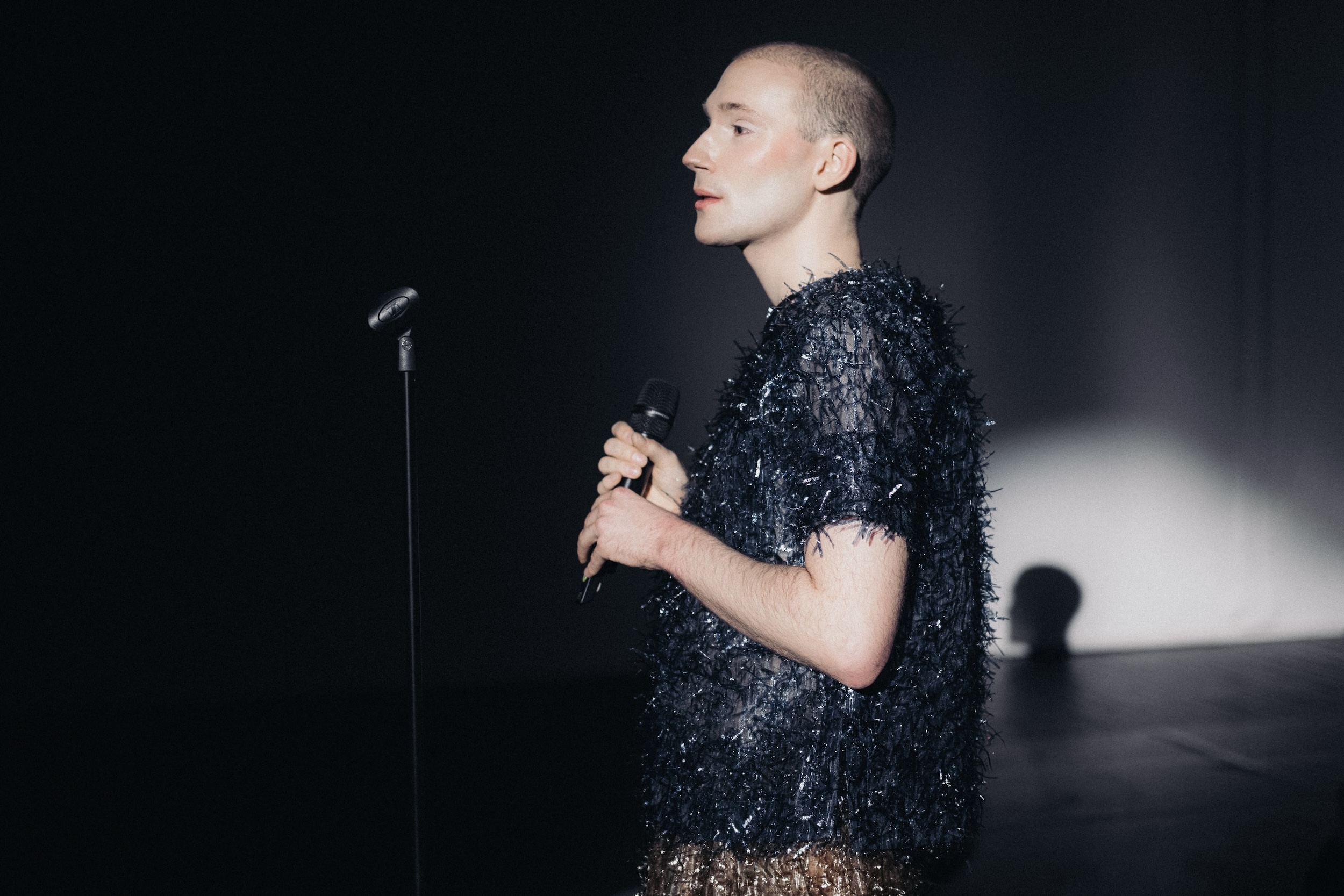 Künstlerisches Schwarz-Weiß-Foto: Verschwommene Nahaufnahme einer Person mit nach hinten geneigtem Kopf und geschlossenen Augen, das Gesicht teils verdeckt; weiche, wellenartige Formen im Hintergrund erzeugen eine traumhafte, meerartige Atmosphäre, passend zum Titel „Mariannes erstes Mal am Meer“.